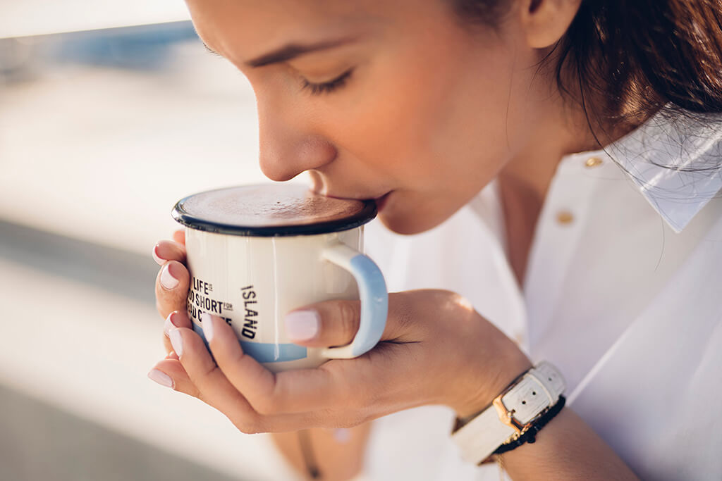 A woman drinking Coffee Island hot chocolate.